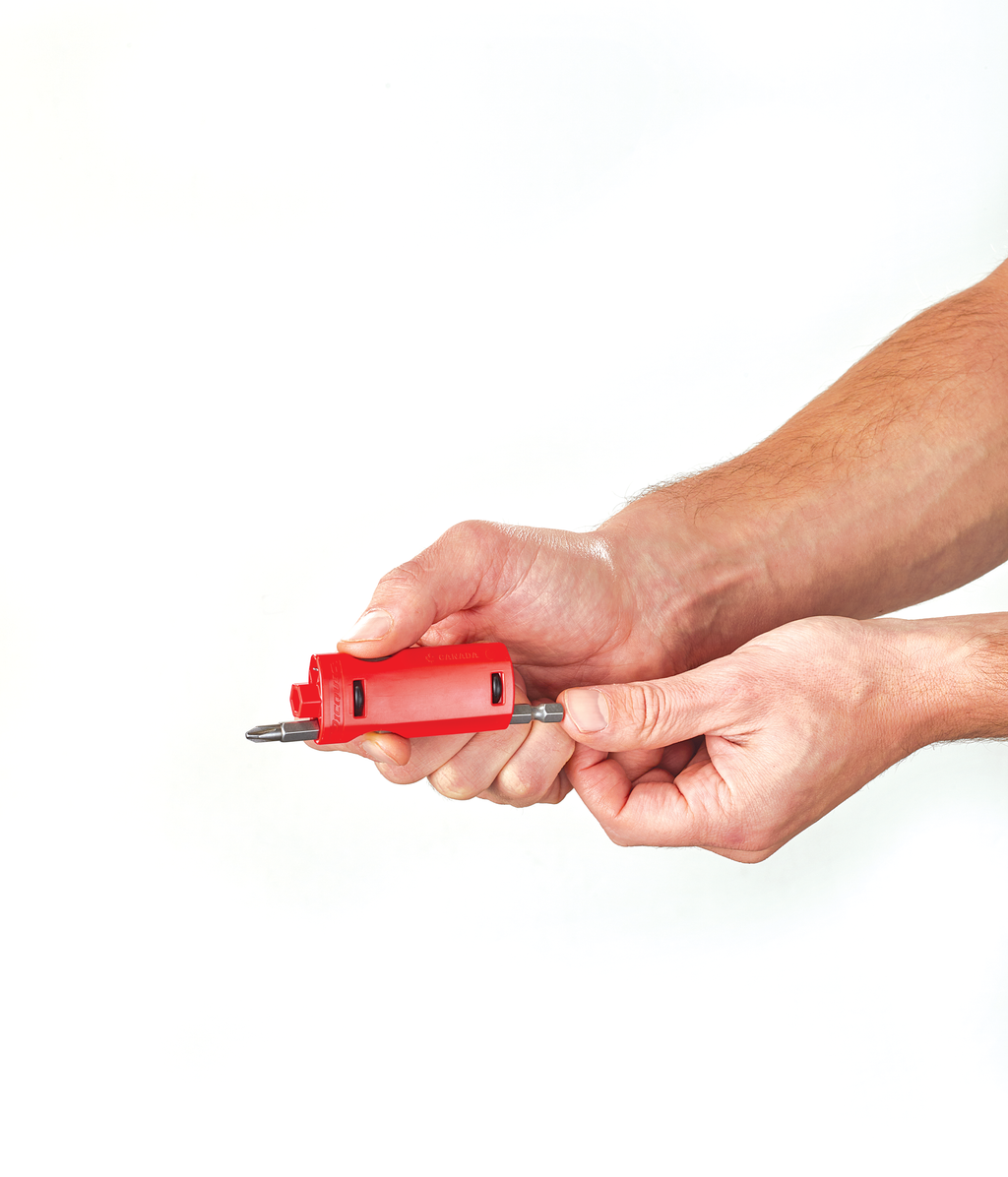 Red screwdriver held by a person's hand on a white background
